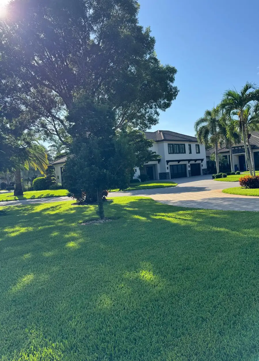 Lush green lawn and mature trees in front of a home